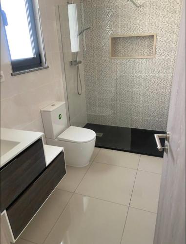 a bathroom with a toilet and a sink and a shower at Luxury Apartment Ocean Views in Praia