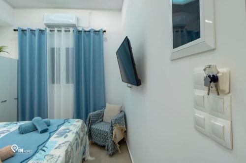 a bedroom with a bed and a tv and a chair at 'The Aqua'House Project In Athens in Athens