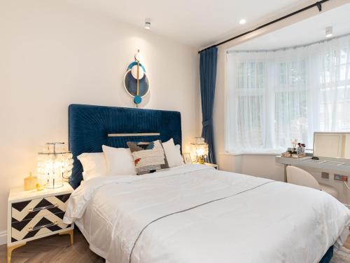 1 dormitorio con 1 cama grande y cabecero azul en Pass the Keys Bright and Airy 3BR New Flat near Central London, en Londres
