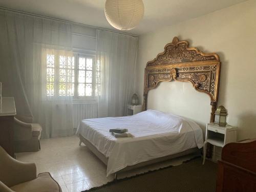 - une chambre avec un grand lit et une grande tête de lit dans l'établissement Le 5 ter, à Tunis