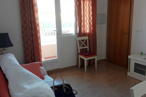 - un salon avec un canapé et une fenêtre dans l'établissement Apartamentos Maruja, à Los Baños