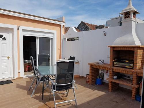 a patio with a glass table and a fireplace at CasaSanPaulo1 in Montijo