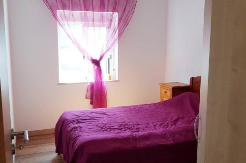 - une chambre avec un lit violet et une fenêtre dans l'établissement CasaSanPaulo1, à Montijo