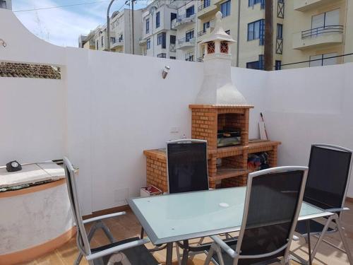 a table and chairs with a fireplace on a balcony at CasaSanPaulo1 in Montijo