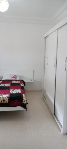 um quarto com uma cama e uma cómoda em Appartement luxeuse em Nassene Srhira