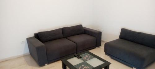 uma sala de estar com um sofá e uma mesa de centro em Appartement luxeuse em Nassene Srhira