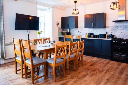 a kitchen with a wooden dining room table and chairs at Albert's Place in Weymouth