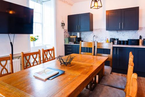 a kitchen with a wooden table and blue cabinets at Albert's Place in Weymouth