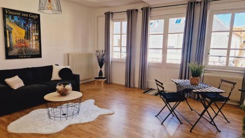 a living room with a couch and a table and chairs at Centre historique de Saverne, bel appartement de 65 m2, Hyper Centre zone piétonne, Parking gratuit à proximité in Saverne