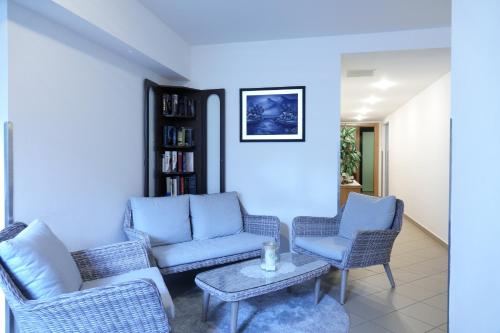 a living room with blue chairs and a table at Hotel Malteinerhof in Malta