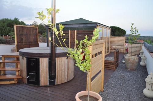 a wooden deck with a bar and a house at Agri Art Croce Vallone in Biancavilla