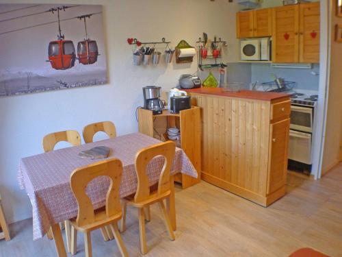 Il dispose d'une cuisine avec une table et des chaises. dans l'établissement Appartement cosy au centre, parking et local à vélos - FR-1-629-20, à Samoëns