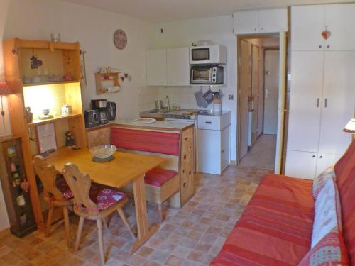 une cuisine avec une table en bois et une cuisine avec une table à manger dans l'établissement Studio coquet avec balcon et parking, centre de Samoëns - FR-1-629-116, à Samoëns