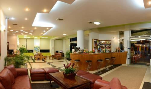 a lobby with leather furniture and a bar at Pegasus Hotel in Stalos