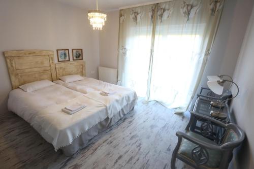 a bedroom with a bed and a large window at Pastel Guesthouse in Balatonfüred