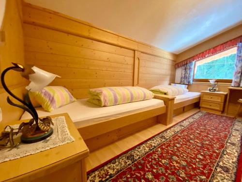 a room with two beds and a table with a lamp at Appartements Hollaus in Gerlos