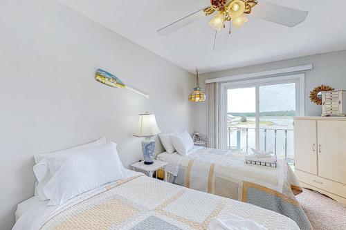 2 camas en una habitación blanca con ventana en Sunset Cove Hideaway, en Wareham