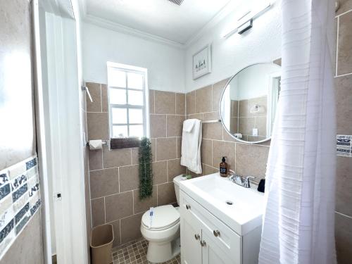 een badkamer met een wastafel, een toilet en een spiegel bij 2 Q Apt W Shared Pool 10 Min Clearwater Beach 4 in Clearwater