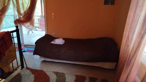 a small bed in a room with a window at Villa Melpo in Likodhrómion