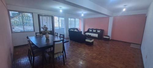 sala de estar con mesa y sofá en Habitacion privada en Departamento, en La Paz