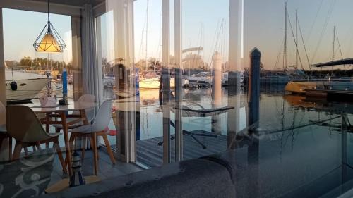 een eetkamer met uitzicht op een jachthaven bij Marina degli Estensi Floating Resort in Lido degli Estensi