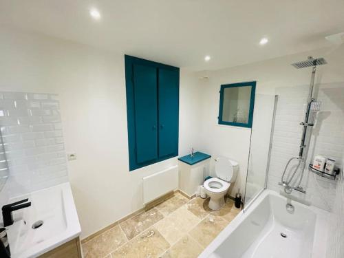 een badkamer met een bad, een toilet en een raam bij L'Escapade Nîmoise - climatisation in Nîmes