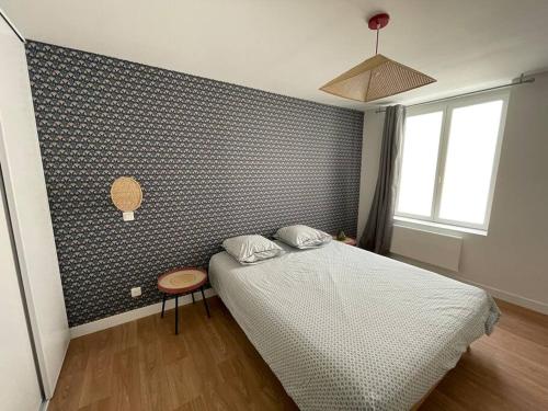 een slaapkamer met een bed en een blauwe muur bij L'Escapade Nîmoise - climatisation in Nîmes