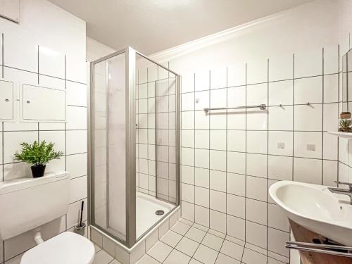 a bathroom with a shower and a toilet and a sink at Sünnslag Wohnung 131 in Boltenhagen