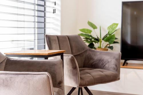 un salon avec deux chaises et une télévision dans l'établissement Waterfront Nieuwpoort, à Nieuport