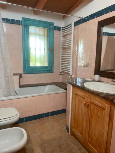 uma casa de banho com uma banheira, um WC e um lavatório. em Villetta Santa Maria em Orosei