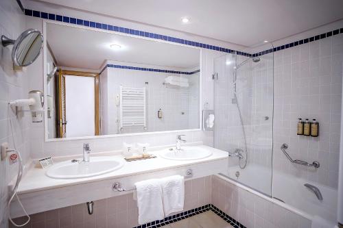 a white bathroom with a sink and a shower at Parador de Mojácar in Mojácar