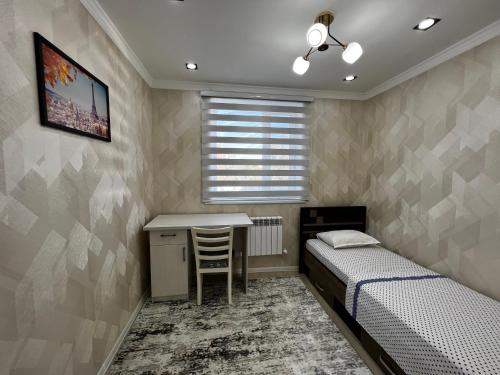 a bedroom with two beds and a desk and a table at Entire Apartment in Central Nukus in Nukus