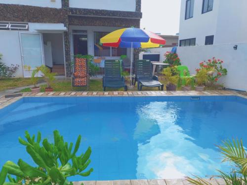 a swimming pool with a table and chairs and an umbrella at 1st floor apartment out of three with pool near sandy beach nearby to rent in Pointe aux Biches