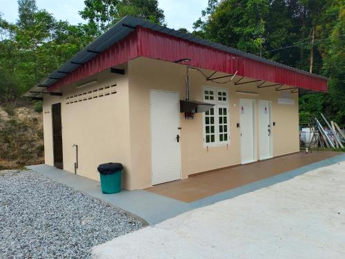 a garage with a red roof and two white doors at ROOMSTAY NIMAZA Bilik 2 in Marang