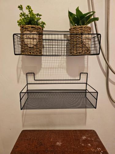 two baskets with plants hanging on a wall at Pai Kiniman Resort in Pai