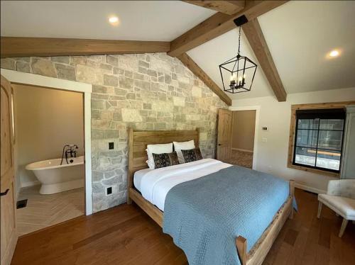 a bedroom with a large bed and a bath tub at Beautiful Craftsman Home with Riverfront Views! in Lander