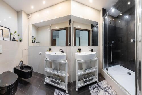 a bathroom with two sinks and a shower at SuperApart Puławska 119 in Warsaw