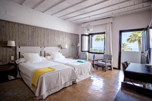 una habitación de hotel con una cama grande y un piano en Parador de Mojácar, en Mojácar