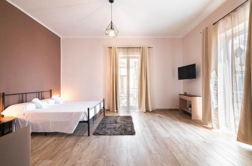 a white bedroom with a bed and a tv at Relais Borbonico Apartment in Naples