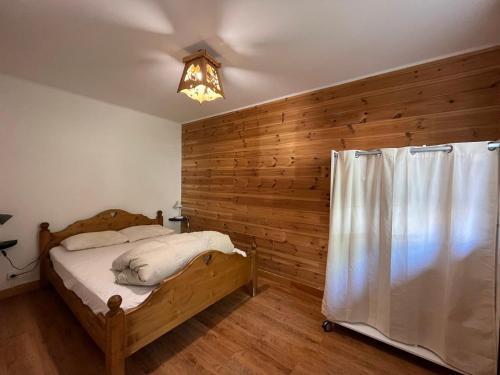 a bedroom with a bed with a wooden wall at Charmant appartement à Pra-Loup avec terrasse, parking, et accès facile aux pistes - FR-1-165A-65 in Uvernet-Fours