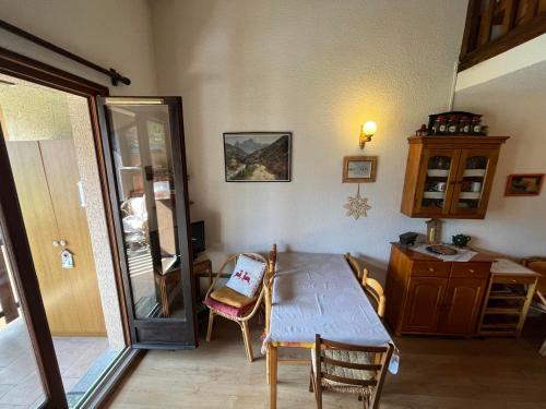une salle à manger avec une table et des chaises et une fenêtre dans l'établissement Mini T2 Duplex avec balcon à Barcelonnette, 1 km centre, idéal pour 4 pers., Animaux interdits - FR-1-165A-27, à Barcelonnette