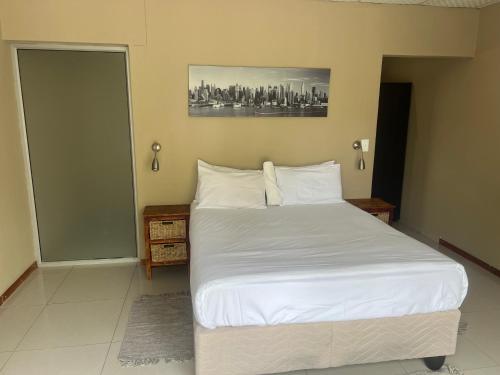 Ondangwa Rest Camp في أوندانغوا: غرفة نوم بسرير كبير مع شراشف بيضاء
