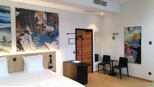 a bedroom with a bed and a desk with two chairs at Comic Art Hotel in Ghent