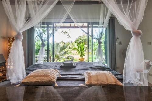 a bedroom with a bed with a large window at Deep Dream Chalet in Hinkong