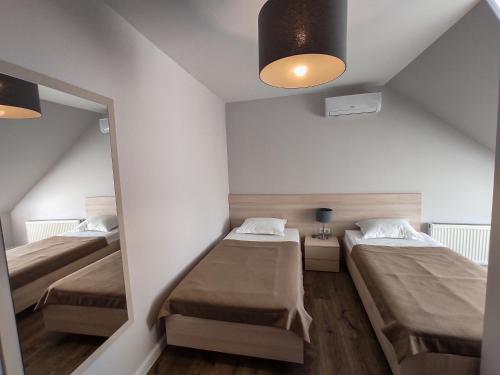イズマイールにあるVIP Hotelの小さな部屋で、ベッド2台、鏡が備わります。