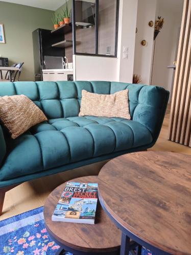 un canapé bleu dans un salon avec une table dans l'établissement Appartement hypercentre avec vue panoramique, à Brest