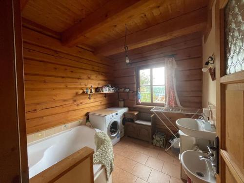 a bathroom with a tub and a sink and a washing machine at Roubenka v Posázaví 