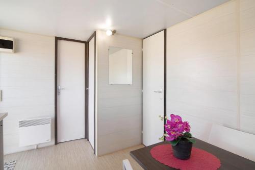 ein Zimmer mit einer Tür und einer Blumenvase auf dem Tisch in der Unterkunft Mobile Home 2 - Olhão in Quelfes