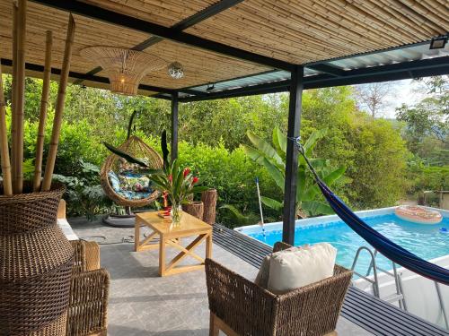 a porch with a hammock and a swimming pool at La mesa cundinamarca in La Mesa