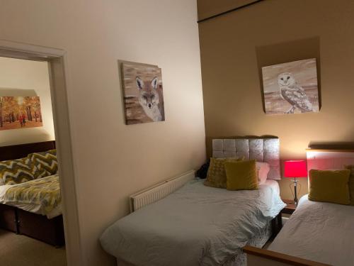 a bedroom with two beds and a mirror at Broadwalk in Coltishall